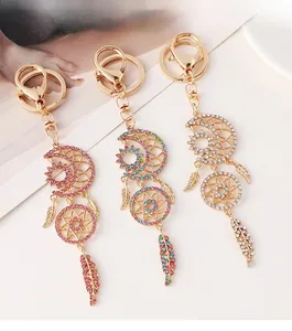 Close-up of crescent moon dreamcatcher keychains with rhinestones and feathers
