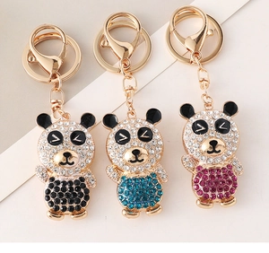 Detailed view of rhinestone panda keychains in black, blue and pink with gold lobster claws