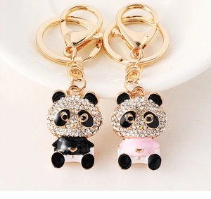 Close-up of diamond-studded panda keychain with golden rings in black and pink colors