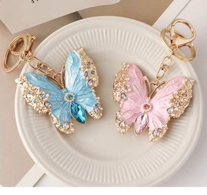 Detail of enamel butterfly keychains with imitation pearls and marquise cut gemstones