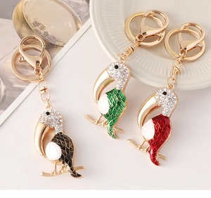 Detail showing toucan keychains with crystal inlay and colorful enamel feather texture