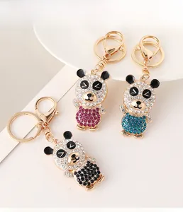 Detailed close-up of three sparkling rhinestone panda keychains in pink, blue, and black colors
