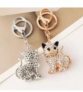 Dettaglio di portachiavi a forma di gatto con strass in finiture oro e argento