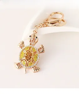 Close-up of golden turtle keychain with yellow rhinestones and hollow-out metal details