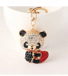 Detail der Panda-Schlüsselanhänger mit Glitzersteinen und rotem Herz auf Vergoldung