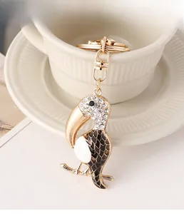 Detail of creative toucan keychain with white rhinestones and gold alloy clasp on a cup