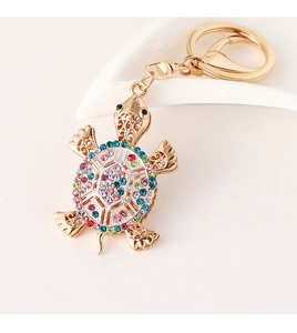 Detailed macro view of a golden turtle keychain with vibrant multicolored rhinestones