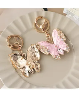 Detail of pink enamel butterfly keychain with pearls and crystals on a decorative ceramic plate