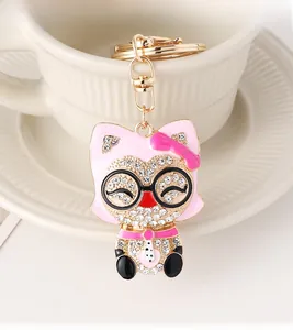 Détail d'un porte-clés renard rose avec strass suspendu au bord d'une tasse en céramique