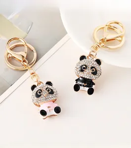 Detail of cute panda keychains with white rhinestones and pink enamel on a porcelain dish