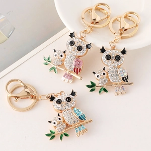 Trois porte-clés hibou ornés de strass en rose, bleu et arc-en-ciel sur alliage doré brillant