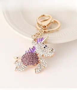 Dettaglio di un portachiavi a forma di unicorno dorato con strass viola brillanti