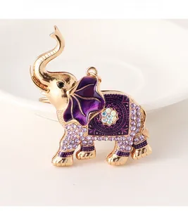 Detail of vintage elephant charm with purple crystals and gold alloy finish on a white plate