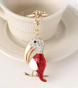 Detailed close-up of toucan keychain with red enamel and white rhinestones on ceramic