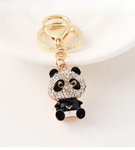 Close-up of golden metal panda keychain with sparkling rhinestones and black enamel finish