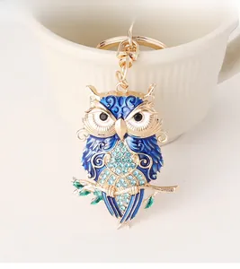 Detailed owl keychain featuring blue enamel wings and sparkling rhinestones on gold metal