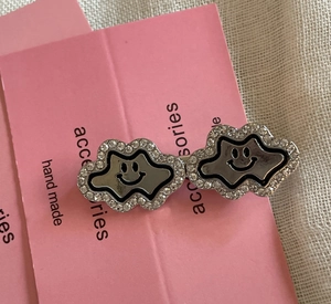 Detail of silver cloud hair clips with sparkling rhinestones and smiling face motif