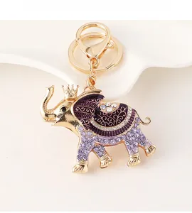 Close-up of golden elephant keychain with purple enamel and sparkling crystal details