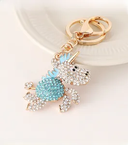 Dettaglio portachiavi a forma di unicorno dorato con strass bianchi e blu cielo