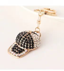 Detailed close-up of sparkling rhinestone-encrusted baseball cap keychain in gold finish