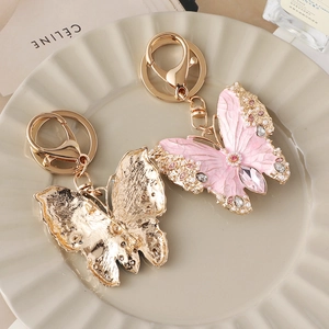 Exquisite pink enamel butterfly keychain and brooch with crystals in a ceramic tray