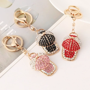 Glittering baseball cap keychains with colorful rhinestones in black, red, and pink