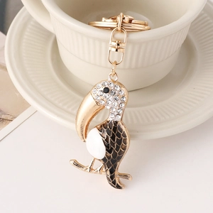 Chic rhinestone toucan bird keychain with gold plating on a ceramic cup edge