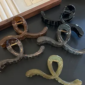 Detail view of five assorted jelly color large hair claws on a dark surface