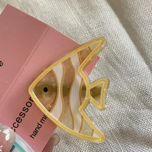 Dettaglio del fermaglio per capelli a pesce tropicale giallo in acetato perlato lucido