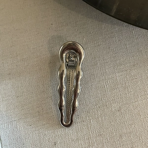 Sleek silver fluid wave metal hair clip with polished mirror finish for women