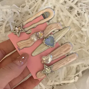 Détail de barrettes à cheveux en marbre rose avec perles et strass sur carte