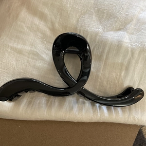 Detailed top view of a glossy black jelly acrylic hair claw clip with metal spring