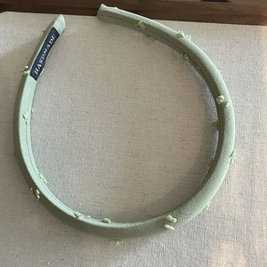 Handmade mint green fabric headband with soft pompom texture and minimalist design