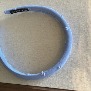 Light blue fabric headband with handmade label on premium textured cloth background