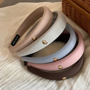 Close-up of assorted sponge headbands in Morandi colors with gold buckle details