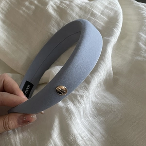Padded sponge headband with matte fabric and a golden metal clasp featuring Believe text