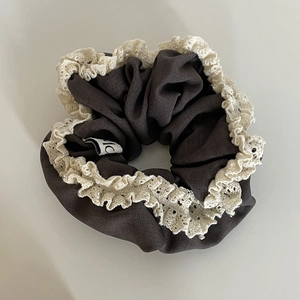 Detail shot of vintage coffee brown hair scrunchie with white lace trim and fabric label
