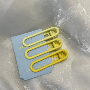 Dettaglio di tre fermagli per capelli a stella gialli su cartoncino blu in metallo opaco