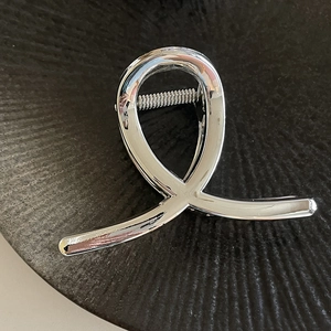 Detailed view of large silver acrylic shark hair clip with polished metallic finish