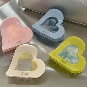 Colorful heart-shaped acetate hair claw clips set in pink, blue, beige, and yellow tones