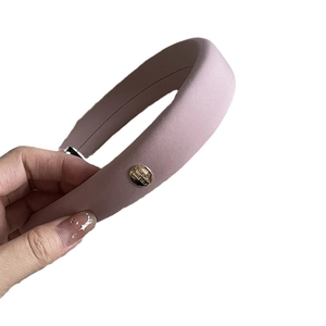 Padded pink sponge headband with golden buckle and motivational engraving on white background