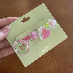 Détail d'élastiques à cheveux cœur en cristal avec motifs I Love You et cerise