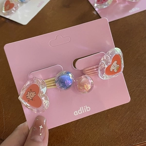 Détail d'élastiques à cheveux avec cœurs en cristal et perles sur carte adlib rose