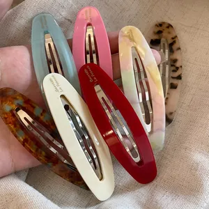 Detail showing various acetate hair clips with France handmade lettering on linen background