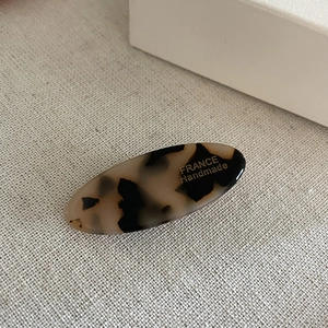 Close-up of tortoise shell acetate hair clip with golden France Handmade lettering