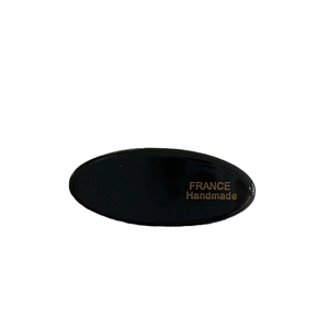 Handmade black acetate oval hair clip with gold label lettering for side hair styling