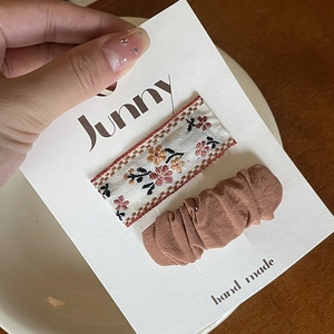 Cute coffee-colored bow hair clips for girls with floral embroidery on display card