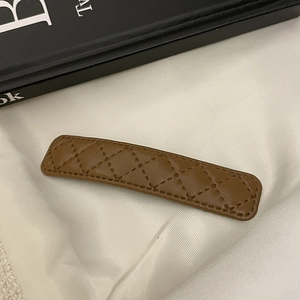 Gros plan sur la barrette en cuir marron matelassé avec motif à losanges élégant