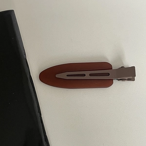 Close-up of matte dark brownish-red jelly color hair clip with minimalist design