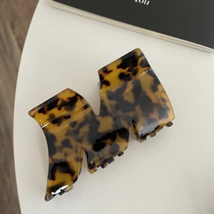 Detail of tortoise shell acetate shark hair clip with M-shape and gold France Handmade logo